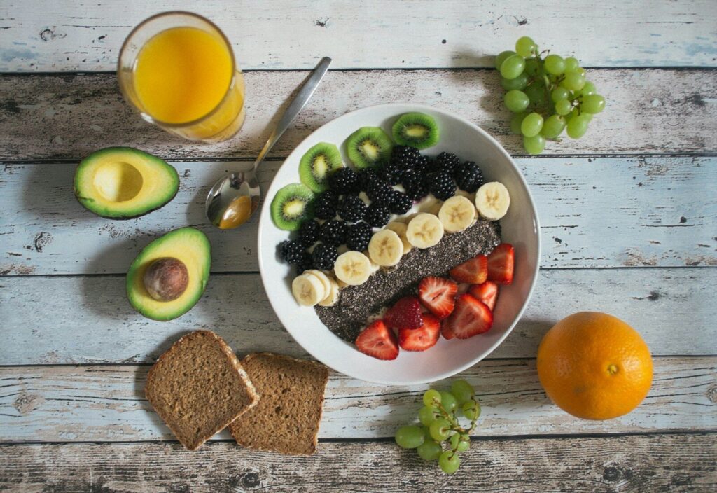 Desayuno saludable con fruta y aguacate sobre una mesa de madera