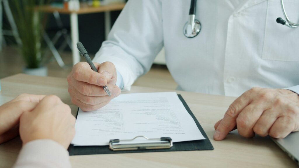 Profesional sanitario tomando notas durante una consulta